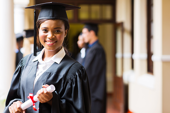 African-American university graduate holding diploma.